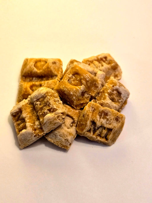 Square-shaped brown maple syrup pillow candy with a MI logo on one side and a heart logo on the other.