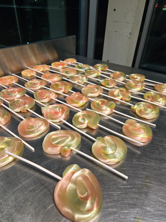 Decorative red and green and pink swirl dye free natural lollipops on a cooling rack